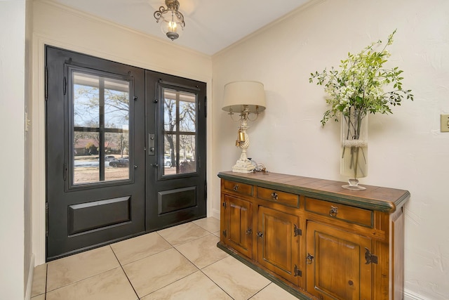 entrance foyer with ornamental molding, french doors, and light tile patterned flooring