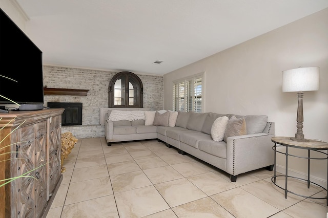 living area featuring light tile patterned flooring, a fireplace, visible vents, and baseboards