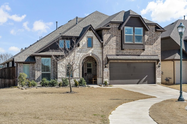 view of front of home featuring an attached garage, brick siding, fence, driveway, and stone siding