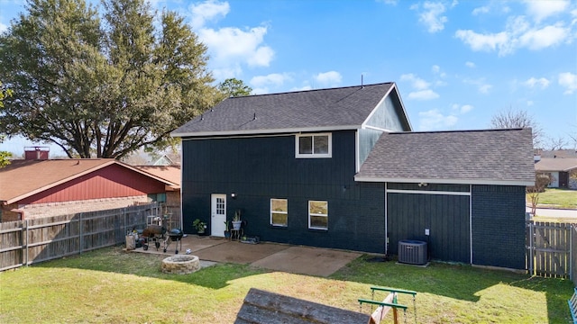 back of house with a fire pit, a yard, brick siding, and an attached garage