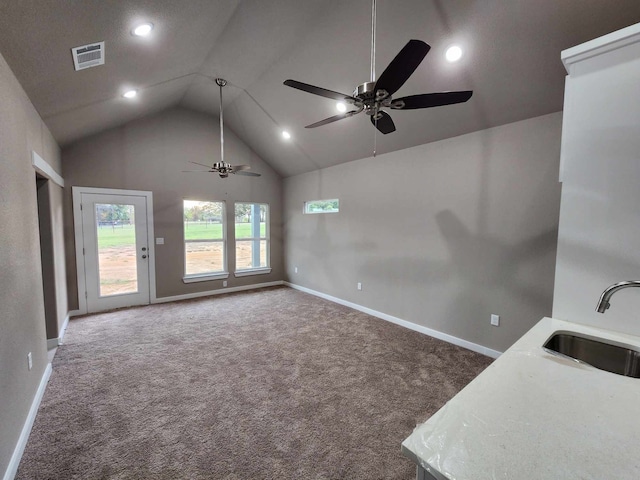 unfurnished living room with baseboards, visible vents, dark carpet, and a sink