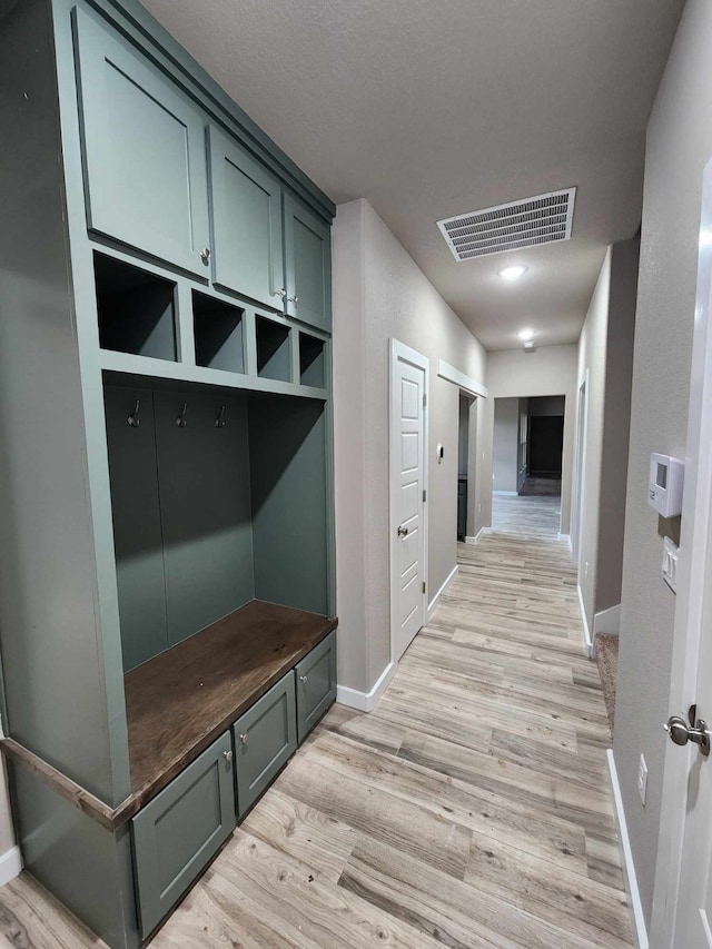 mudroom with light wood-style flooring, visible vents, and baseboards