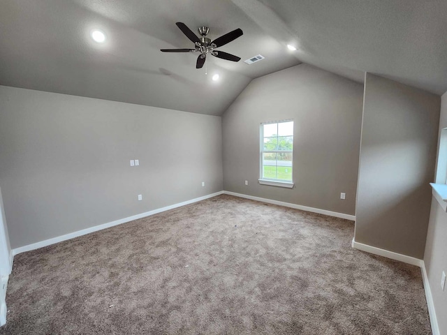 additional living space featuring ceiling fan, carpet flooring, visible vents, baseboards, and vaulted ceiling