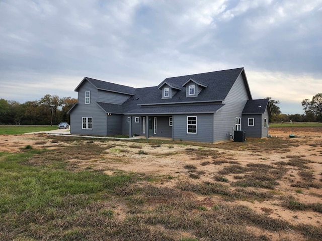 view of front of home with central AC and roof with shingles