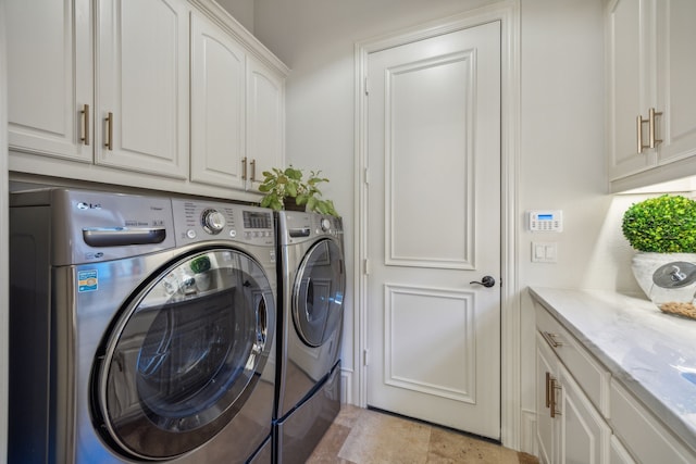 washroom with cabinet space and washer and clothes dryer