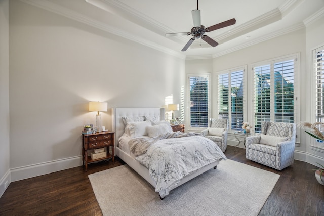 bedroom featuring ceiling fan, baseboards, dark wood-style floors, a tray ceiling, and crown molding