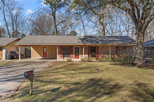 ranch-style home with concrete driveway, a carport, and a front lawn