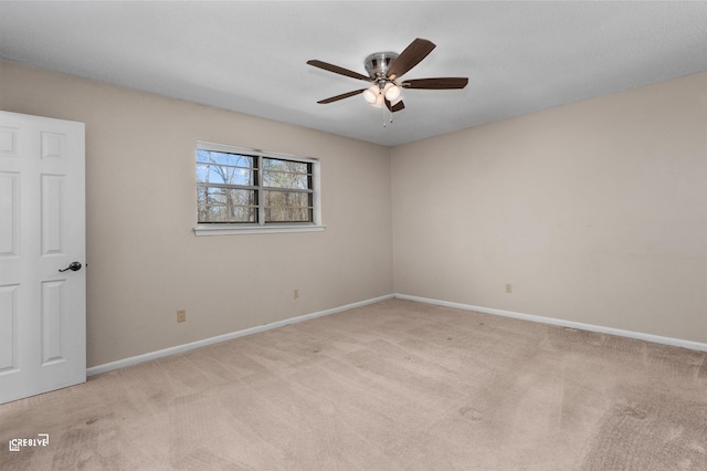 unfurnished room featuring baseboards, ceiling fan, and light colored carpet