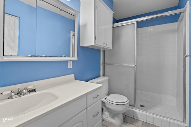 full bathroom featuring vanity, a shower stall, toilet, and tile patterned floors