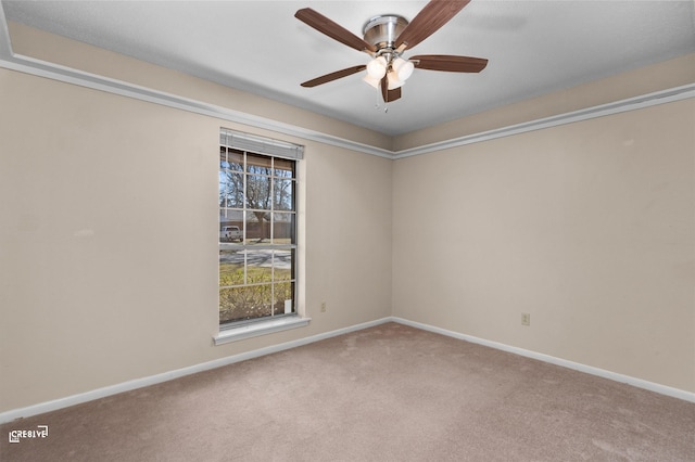 carpeted empty room with baseboards and a ceiling fan