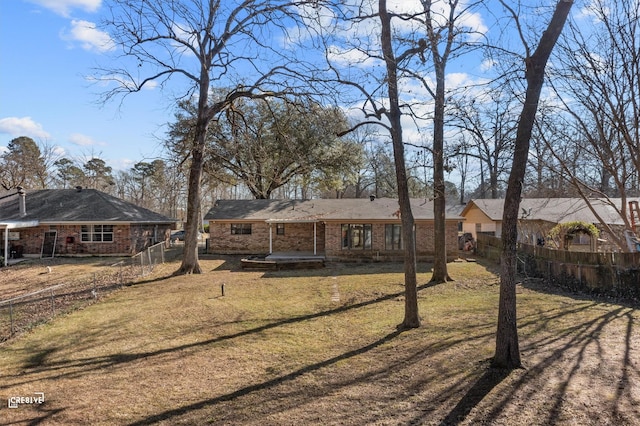 view of front of property featuring fence private yard, a front lawn, and brick siding