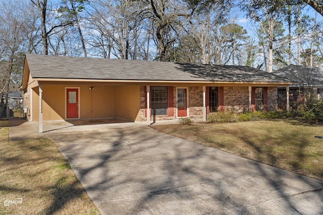 ranch-style home with driveway, brick siding, and a front yard