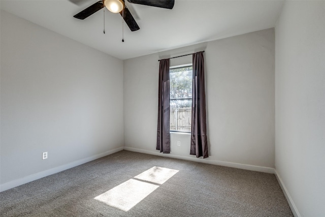 empty room with carpet floors, a ceiling fan, and baseboards