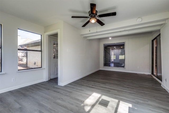 unfurnished room with stairway, wood finished floors, a ceiling fan, and baseboards