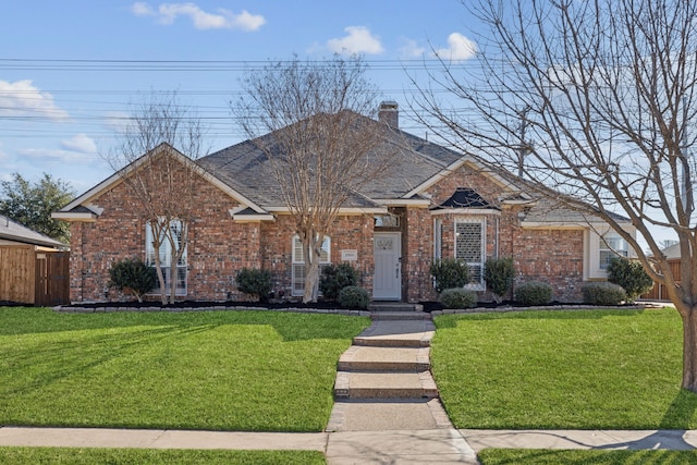 view of front of house featuring fence, a front lawn, and brick siding