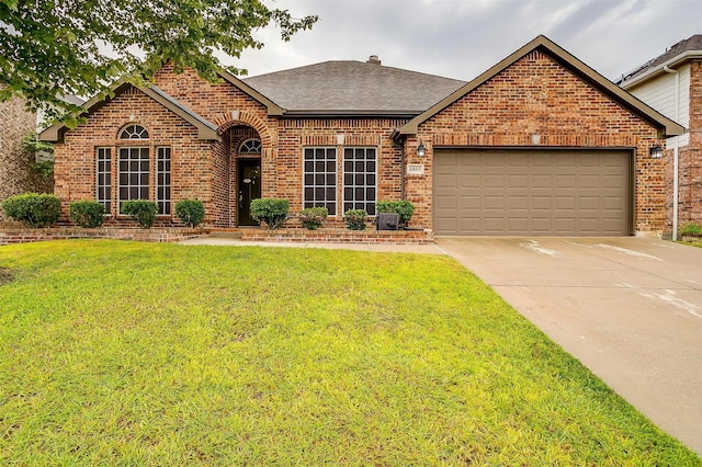 view of front of house with brick siding, a shingled roof, concrete driveway, an attached garage, and a front lawn