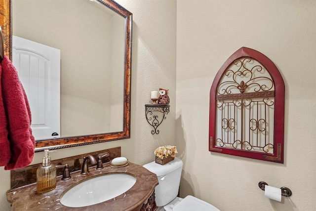 half bathroom with vanity and toilet