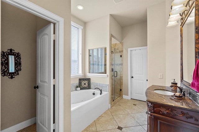 bathroom featuring a garden tub, vanity, a shower stall, tile patterned flooring, and baseboards