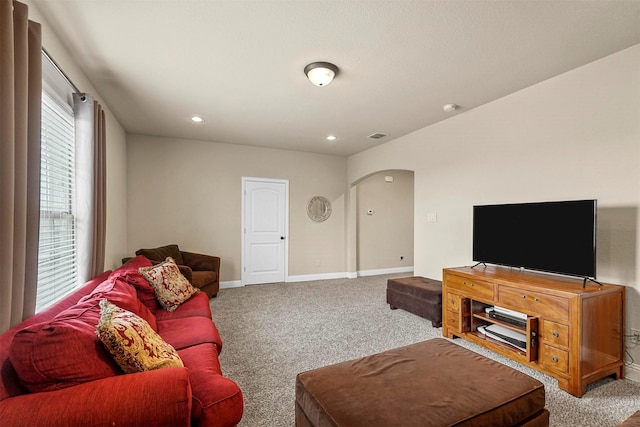 living area with carpet floors, baseboards, arched walkways, and recessed lighting