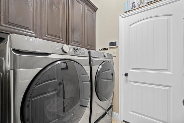 washroom featuring washing machine and dryer and cabinet space