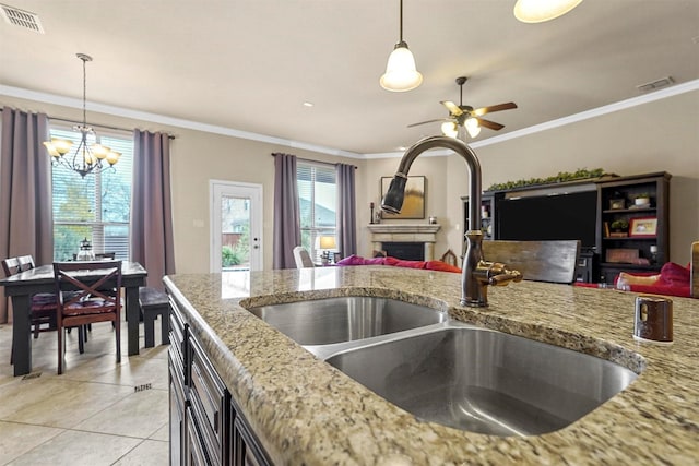 kitchen with a fireplace, a sink, visible vents, and pendant lighting