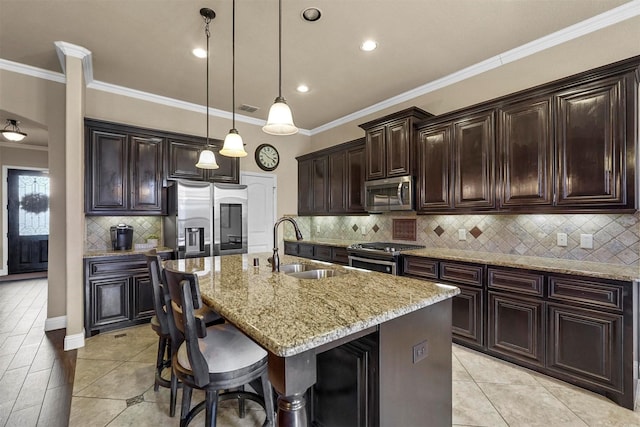 kitchen with a breakfast bar, dark brown cabinetry, a center island with sink, and stainless steel appliances