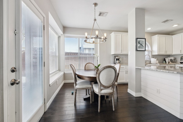 dining space with a chandelier, visible vents, dark wood finished floors, and baseboards