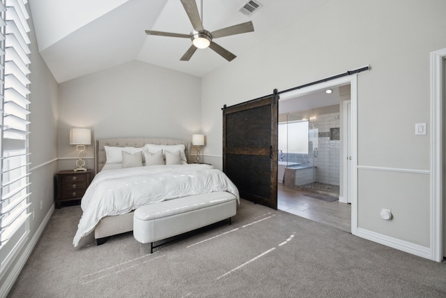 bedroom with carpet, visible vents, ensuite bathroom, a barn door, and vaulted ceiling