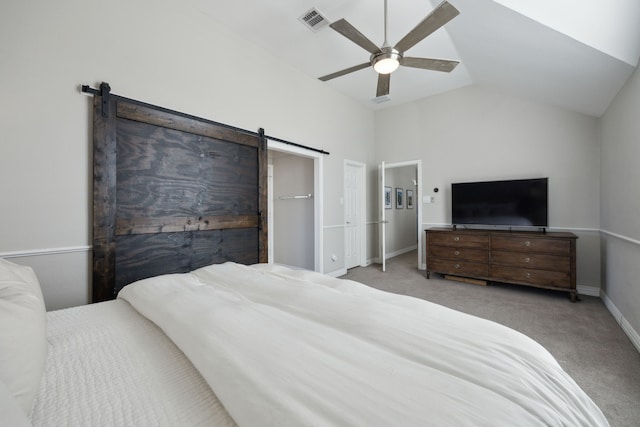 bedroom featuring a barn door, light colored carpet, a ceiling fan, visible vents, and vaulted ceiling