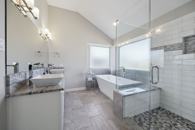 full bathroom featuring lofted ceiling, a sink, a soaking tub, a shower stall, and double vanity