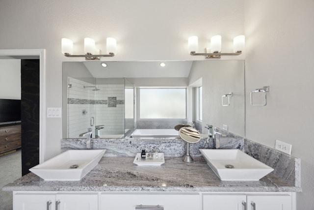 bathroom with lofted ceiling, a stall shower, double vanity, and a sink