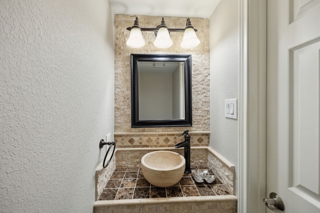 bathroom featuring a textured wall