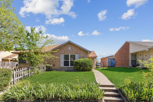 ranch-style home featuring a front yard, brick siding, and fence