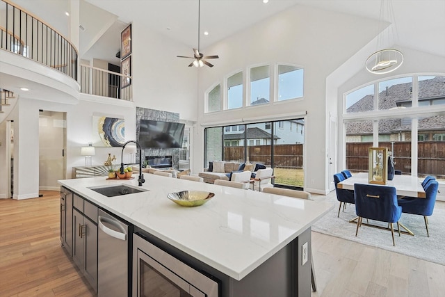 2840 Killdeer Trl, Prosper, TX 75078 - kitchen with a sink, appliances with stainless steel finishes, high vaulted ceiling, open floor plan, and light wood finished floors