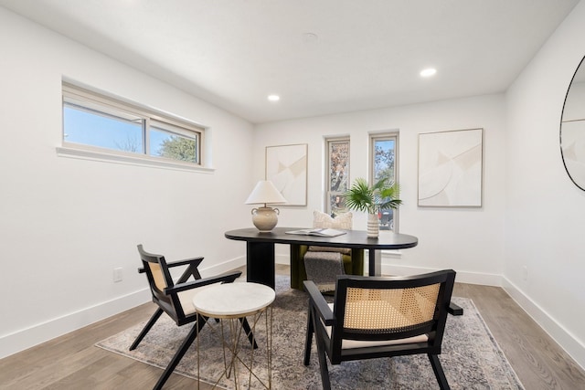 dining room featuring baseboards, wood finished floors, and recessed lighting