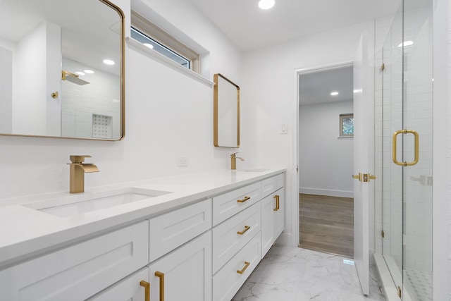 full bath with marble finish floor, a sink, a shower stall, and double vanity