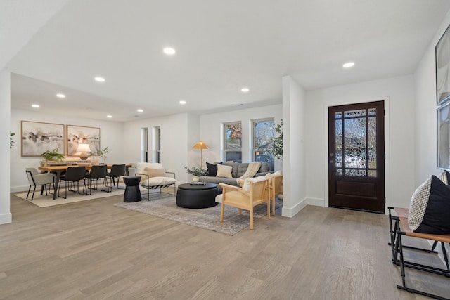 living room featuring light wood-style floors, baseboards, and recessed lighting