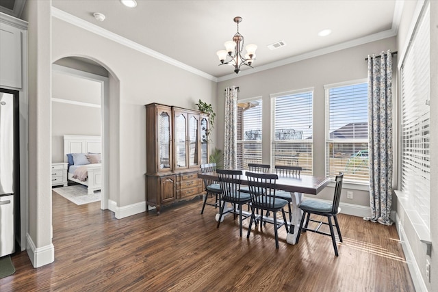 dining space with dark wood-style floors, arched walkways, and plenty of natural light