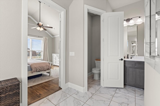 bathroom with marble finish floor, vaulted ceiling, baseboards, and toilet