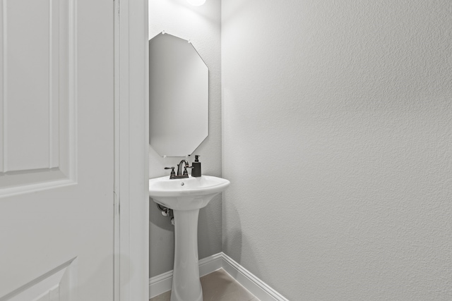 bathroom with baseboards and a textured wall