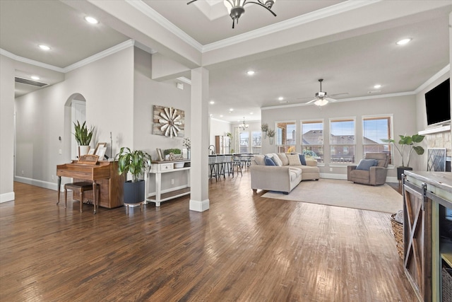 living room with baseboards, wood finished floors, crown molding, a fireplace, and recessed lighting