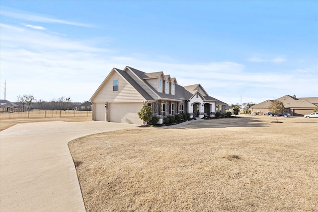 view of front of home with a garage, concrete driveway, and a front yard