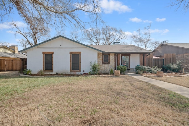 single story home featuring stone siding, fence, and a front lawn