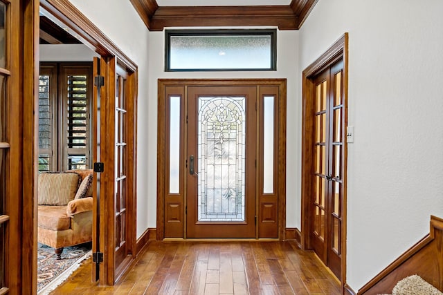 foyer featuring hardwood / wood-style floors and crown molding