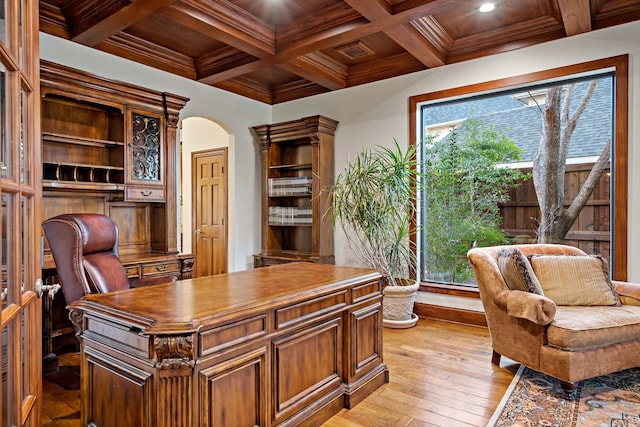 office featuring light wood-style floors, arched walkways, beam ceiling, and coffered ceiling