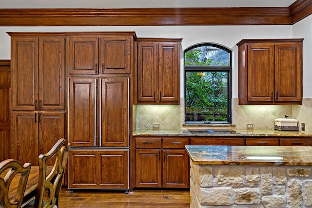 kitchen featuring dark wood-style floors, light stone counters, and decorative backsplash