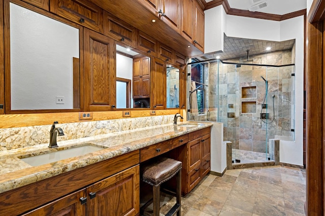 bathroom with ornamental molding, a stall shower, a sink, and visible vents