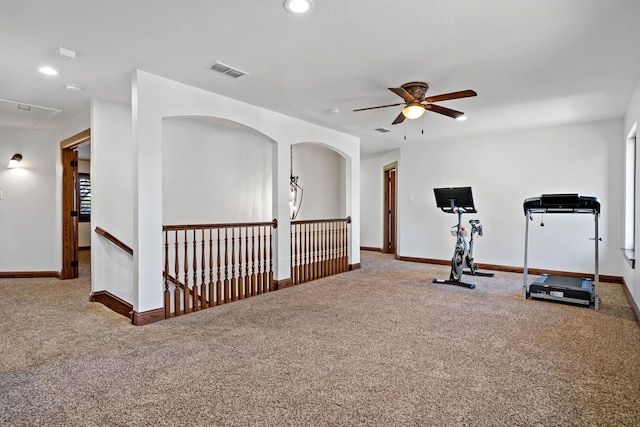 exercise room featuring carpet floors, attic access, visible vents, and baseboards