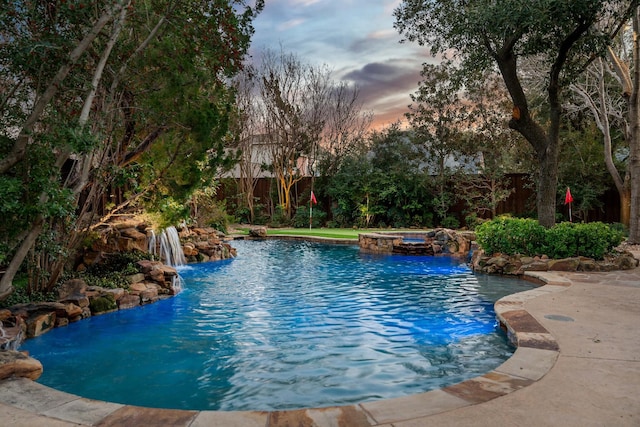 view of pool with a fenced backyard and a pool with connected hot tub