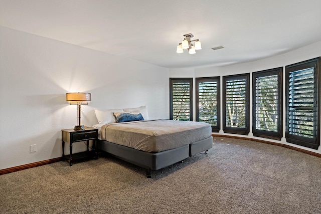 carpeted bedroom featuring a chandelier, visible vents, and baseboards